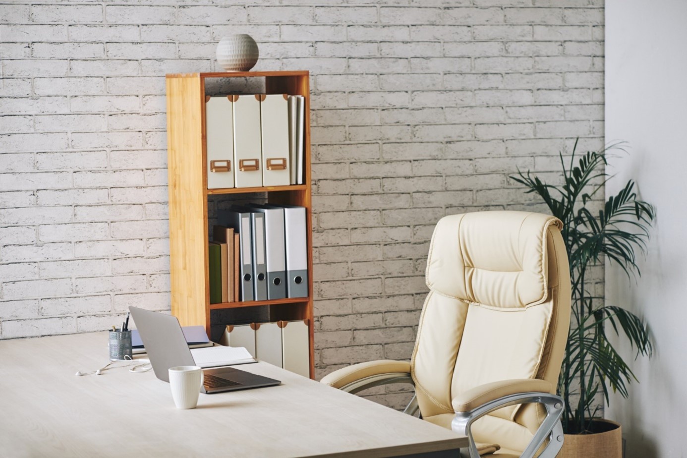 Jasne duże krzesło ergonomiczne stoi przy biurku w biurze